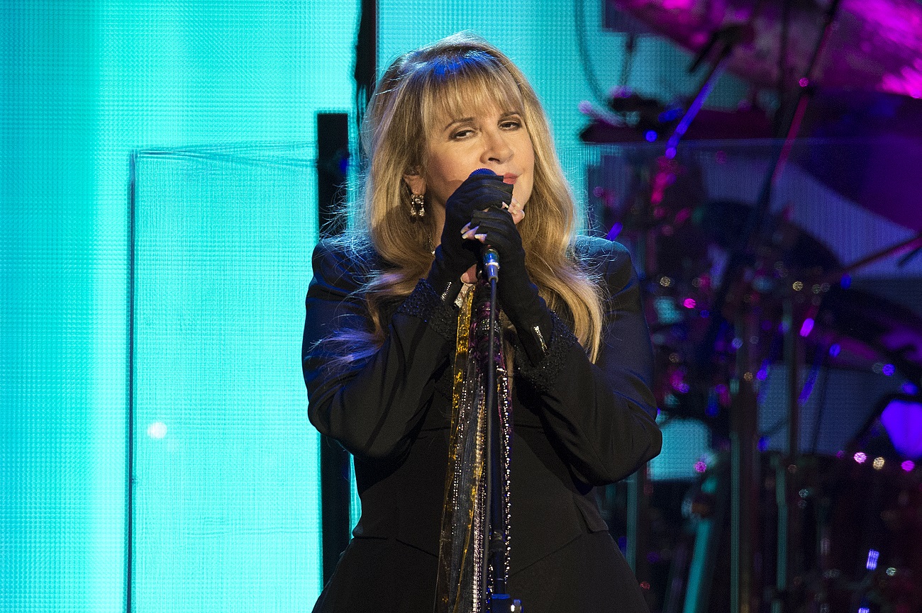 Stevie Nicks holds a microphone while on tour in Denver.