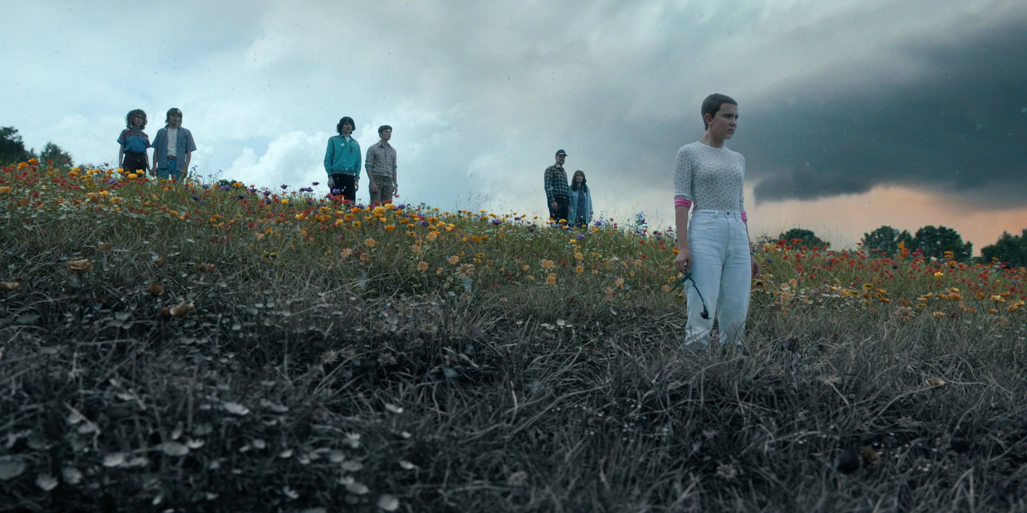 'Stranger Things' Season 5 will have shorter episodes than 'Stranger Things' Season 4. In this production still, the main characters stand on a hillside as the Upside Down begins to take over Hawkins.
