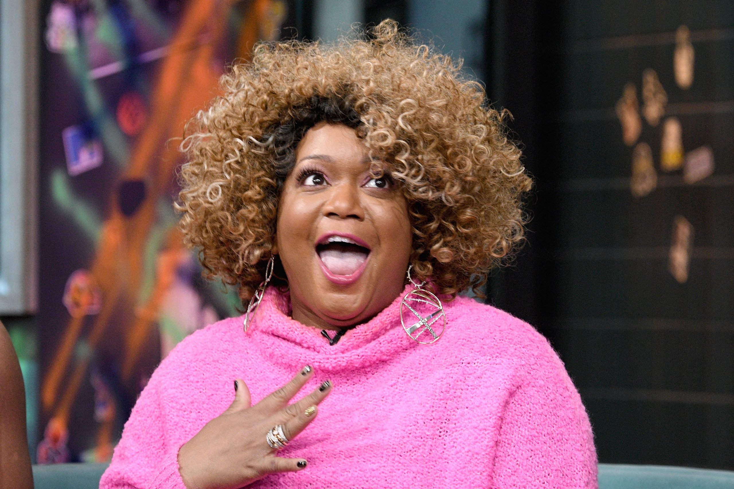 Culinary celebrity Sunny Anderson wears a pink sweater in this photograph.