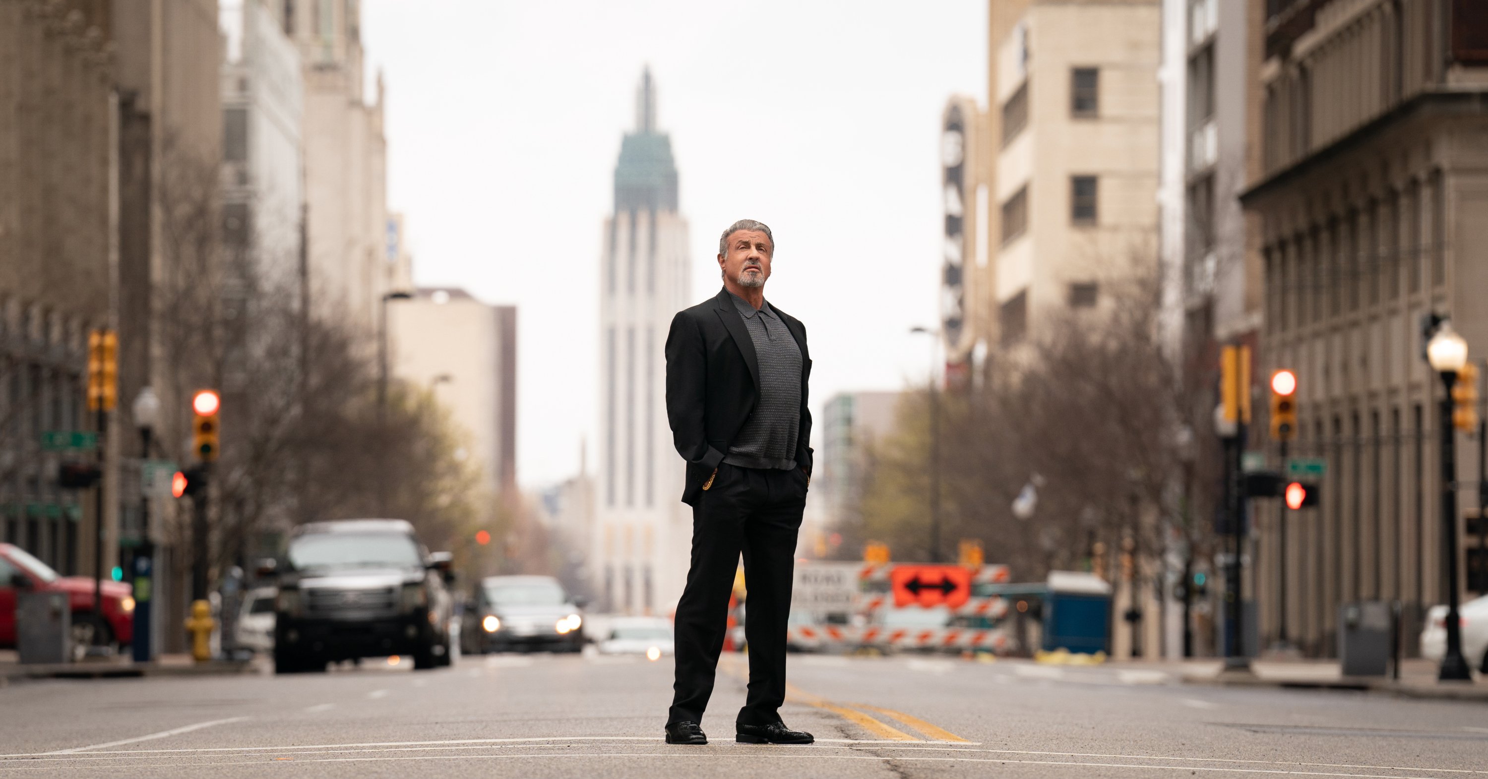 Sylvester Stallone standing in the middle of a city street in promo shot for the Paramount+ series 'Tulsa King'