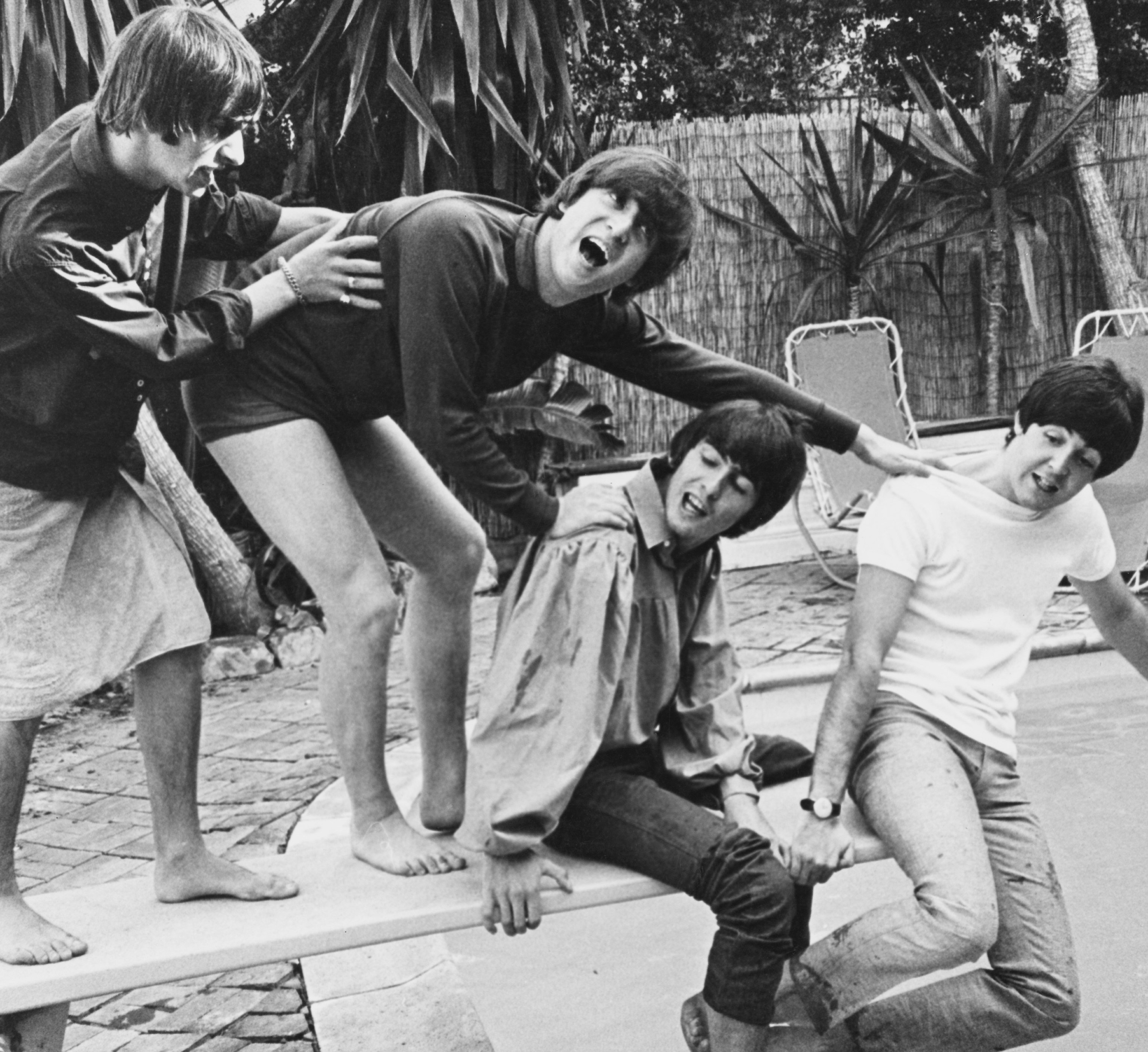 The Beatles' Ringo Starr, John Lennon, George Harrison, and Paul McCartney near a pool