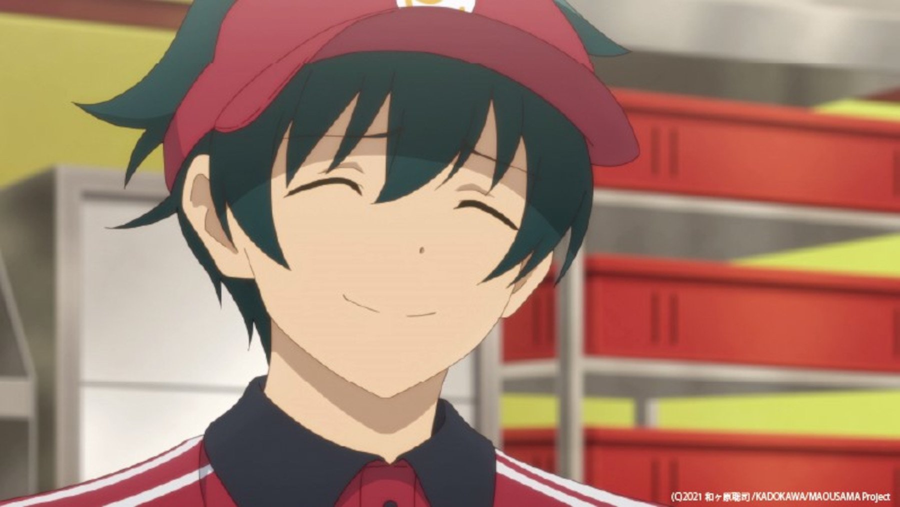 Sadao Maou in 'The Devil Is a Part-Timer' Season 2, which airs new episodes every Thursday. He's smiling and wearing a red visor.