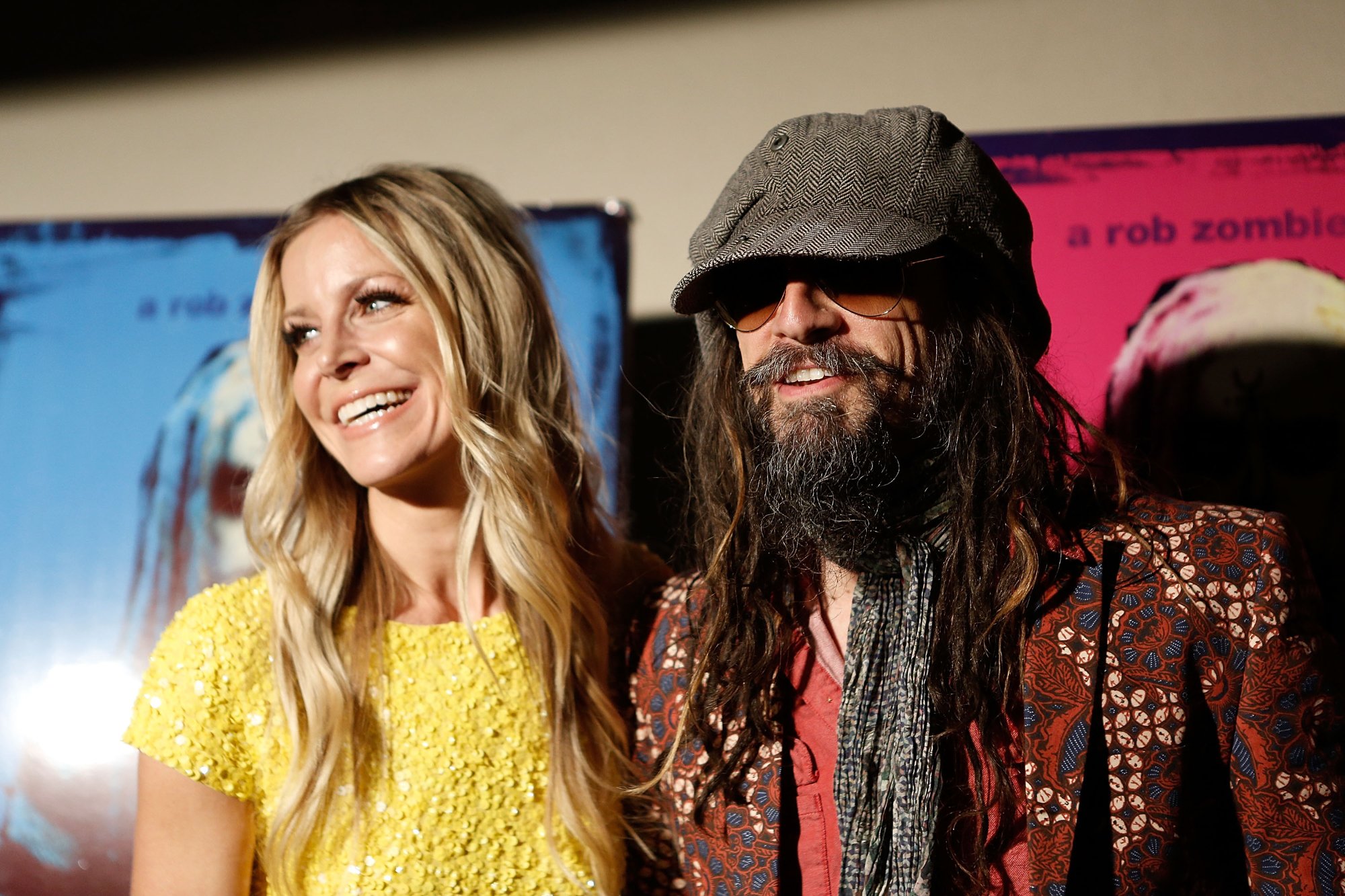 'The Munsters' actor Sheri Moon Zombie and director Rob Zombie, whose trailer is getting slammed. They're smiling for press in front of 'Lords of Salem' poster.
