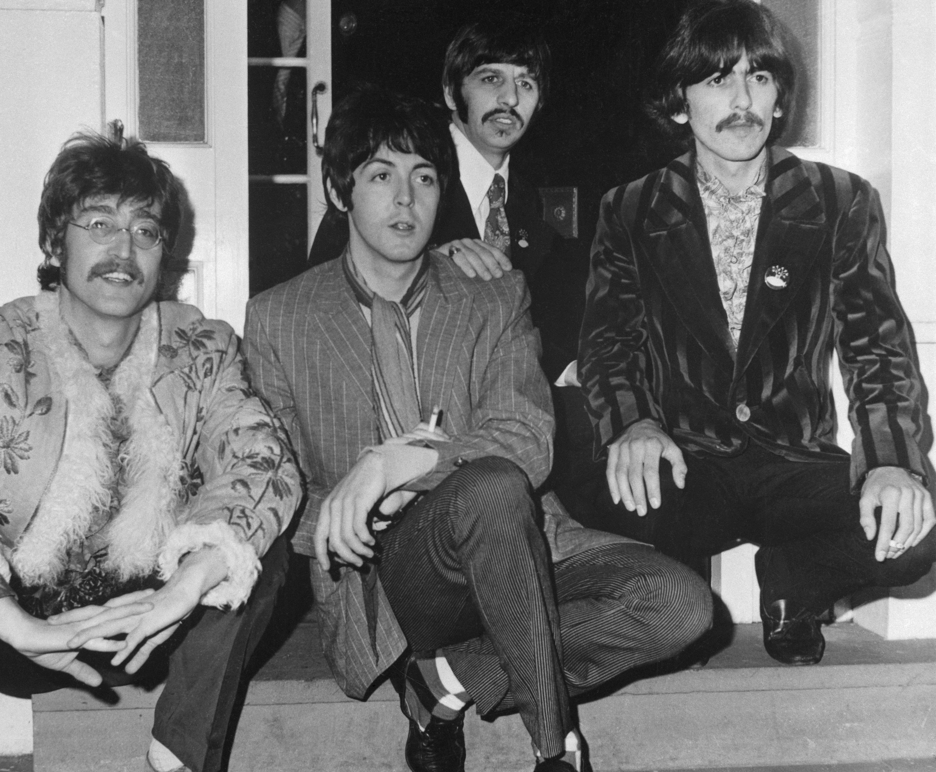 The Beatles' John Lennon, Paul McCartney, Ringo Starr, and George Harrison on a step during the "Get Back" era