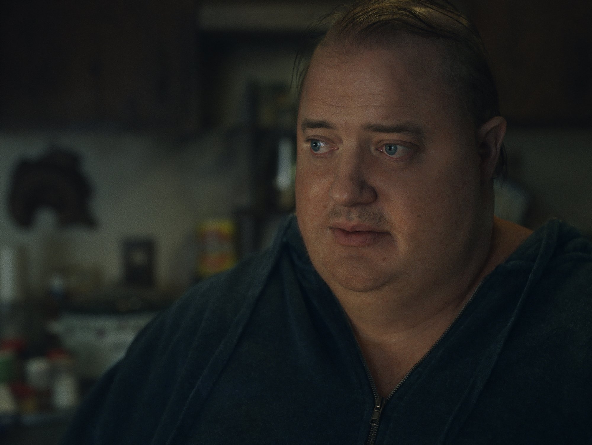 'The Whale' Brendan Fraser as Charlie looking straight ahead with bottles blurred out in the background