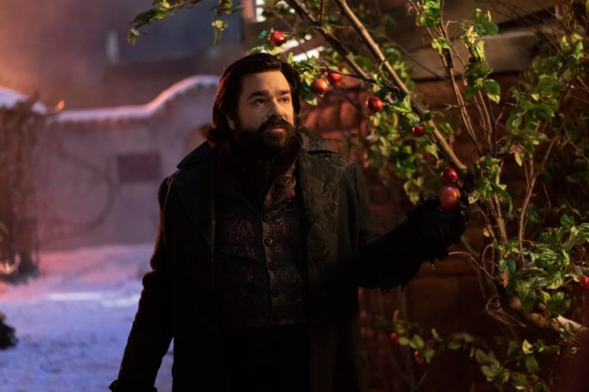 Matt Berry yells bat in What We Do in the Shadows. Laszlo stands outside holding an apple. 