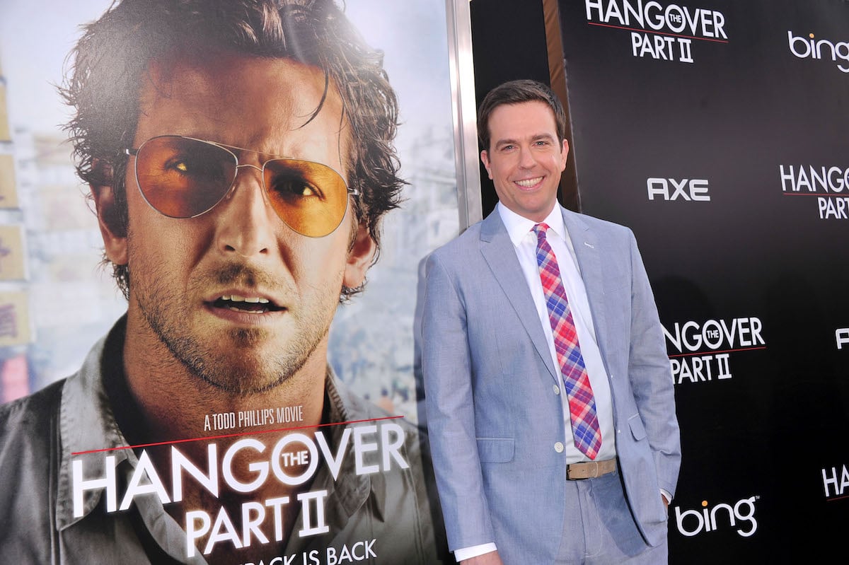 Ed Helms in front of a 'The Hangover Part II' poster