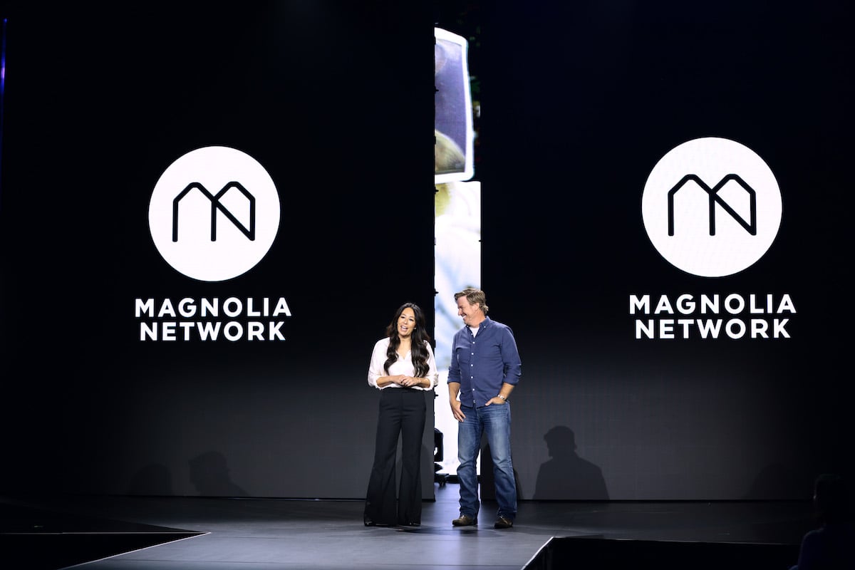 Joanna Gaines and Chip Gaines speak on a stage in front of Magnolia Network logos.
