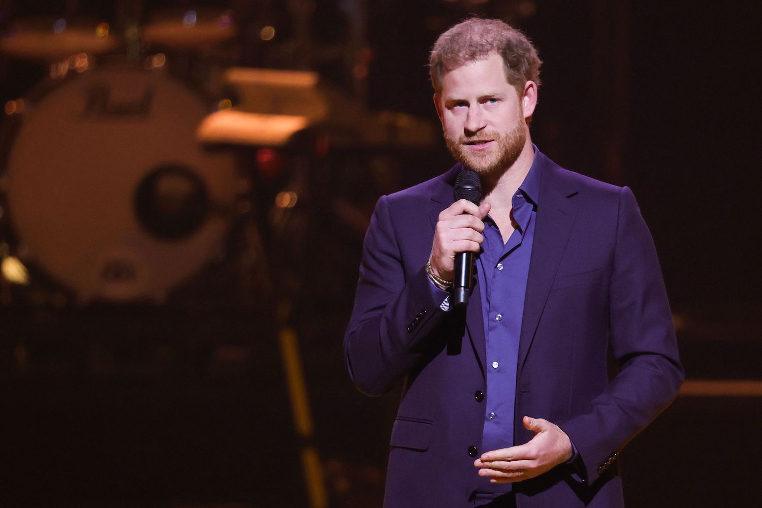 Prince Harry body language shows hand gesture while he speaks into a microphone during Invictus Games