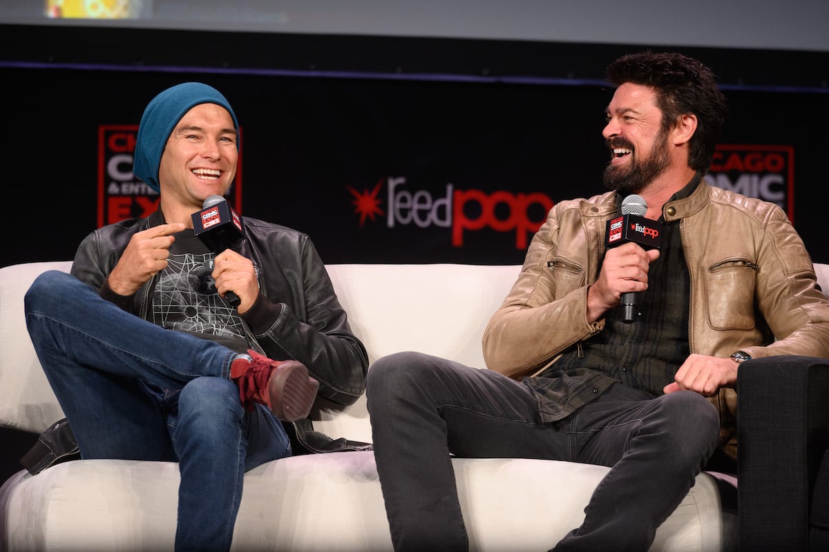 'The Boys' stars Antony Starr and Karl Urban, who play Homelander and Butcher, sitting on a sofa together holding microphones