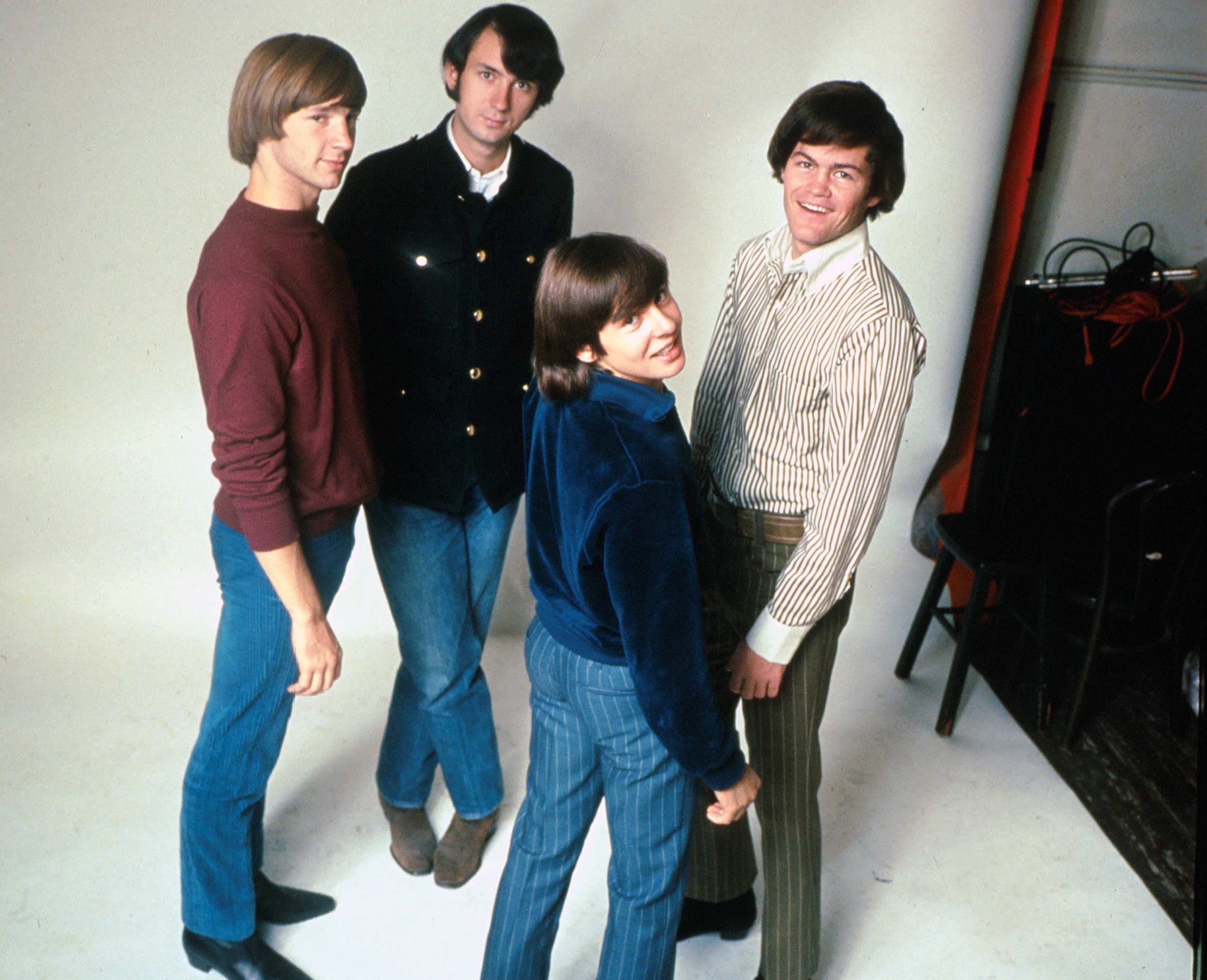 The Monkees' Peter Tork, Mike Nesmith, Davy Jones, and Micky Dolenz with a white background