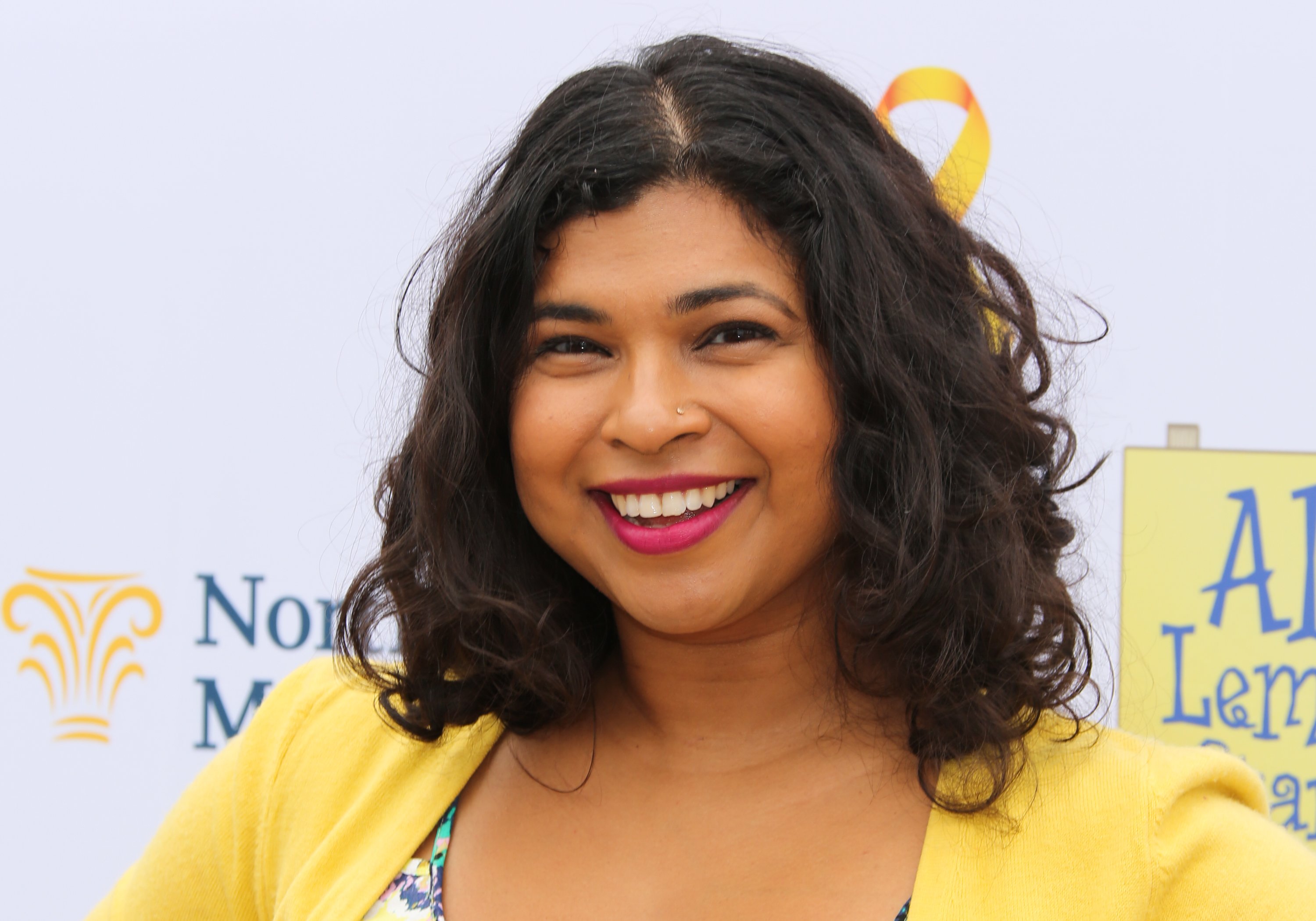 Food Network star Aarti Sequeira wears a yellow sweater in this photograph.