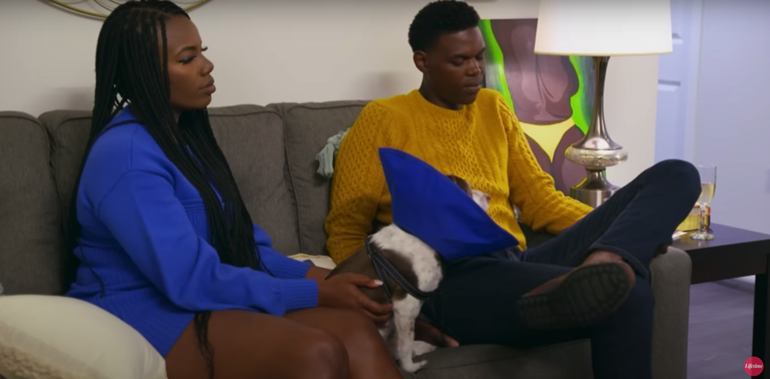 Alexis and Justin sitting on a couch with her dog Newton in 'Married at First Sight' Season 15