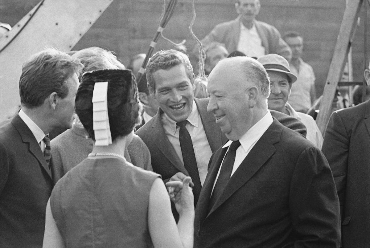 Paul Newman smiles at Alfred Hitchcock during a media event in 1965