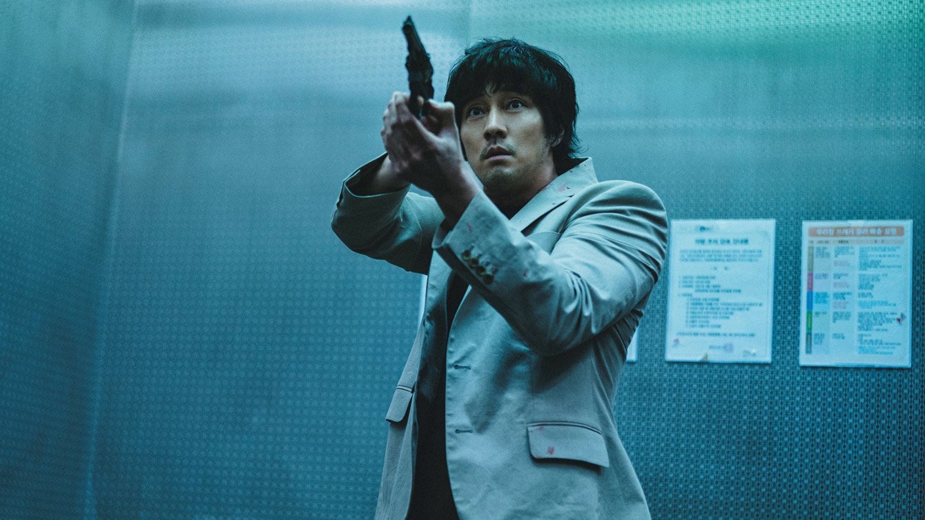 A still from South Korean film, 'Alienoid' showing So Ji-sub as Moon Do-seok holding a gun. 