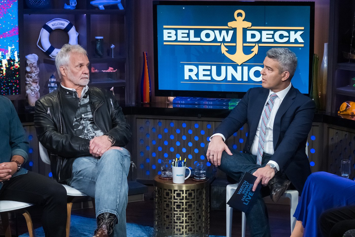 Captain Lee Rosbach from 'Below Deck' sits, looking at Andy Cohen in the 'WWHL' clubhouse during the reunion 