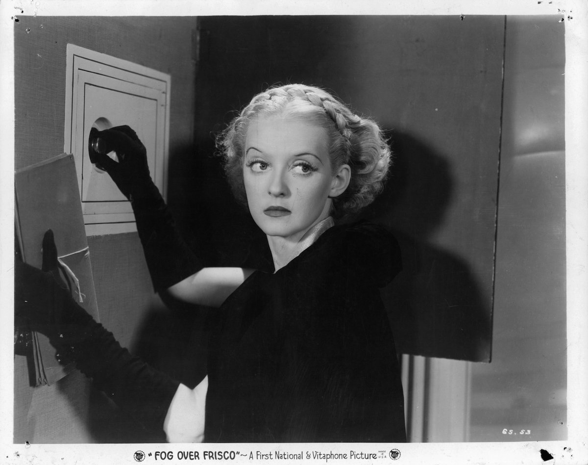 Bette Davis opening up safe in a scene from the 1934 film 'Fog Over Frisco'