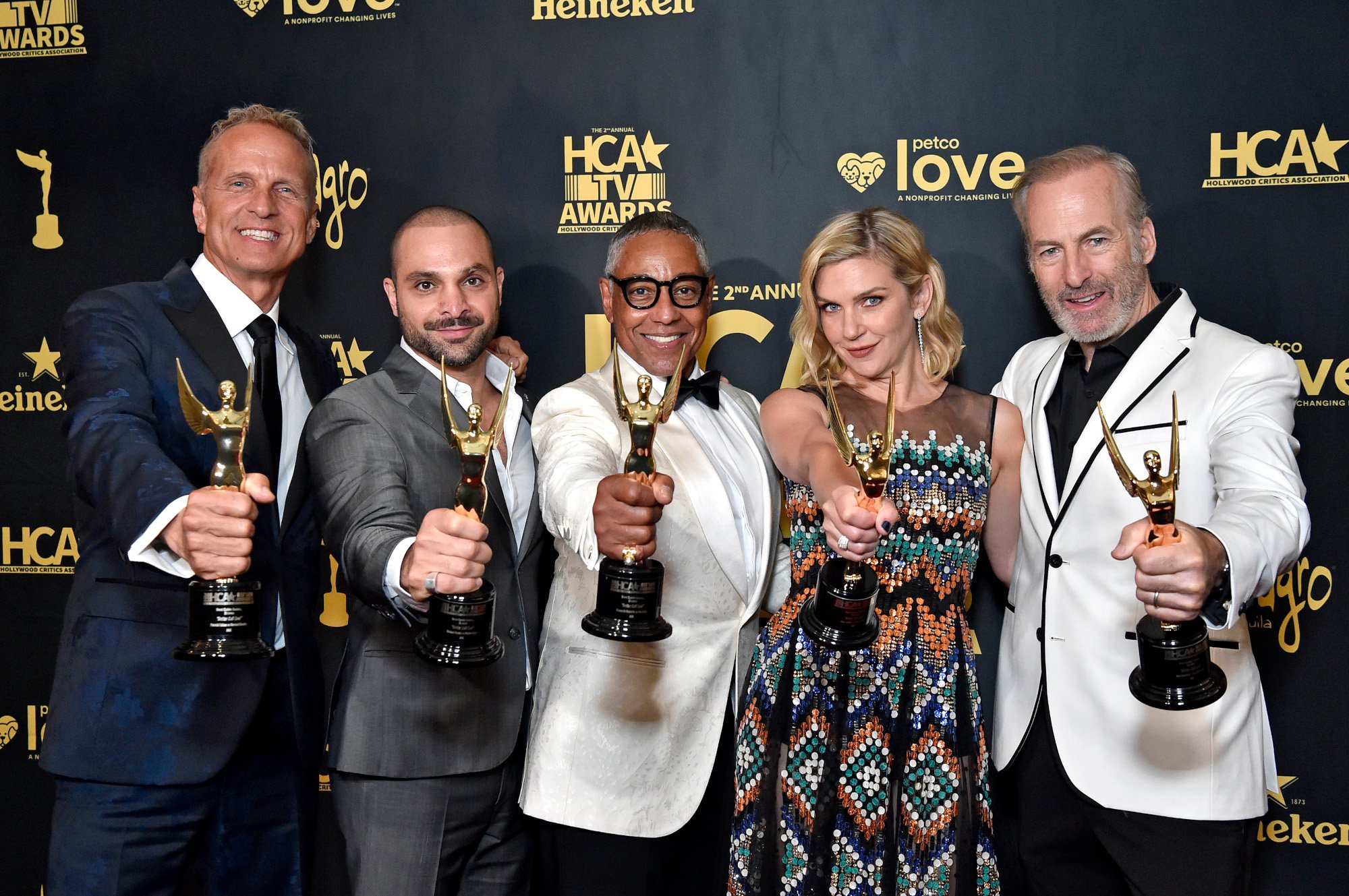 The cast of 'Better Call Saul,' including Patrick Fabian, Michael Mando, Giancarlo Esposito, Rhea Seehorn, and Bob Odenkirk. They're standing in a row and holding trophies out.