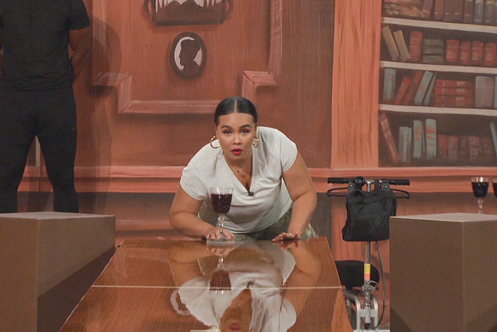 Jasmine Davis competes in a Head of Household competition during 'Big Brother 24' on CBS. Jasmine wears a light blue shirt while trying to slide a glass down a table.