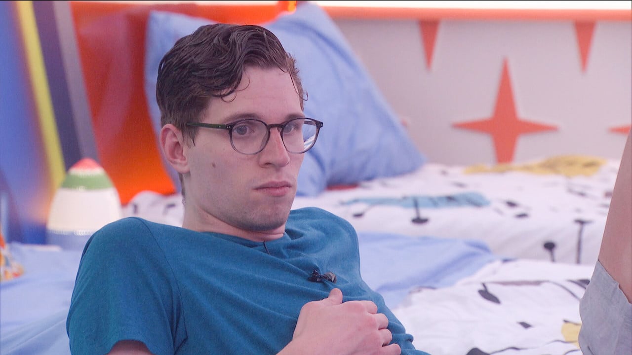 Michael Bruner leans back in bed with a serious look on his face in 'Big Brother 24'.