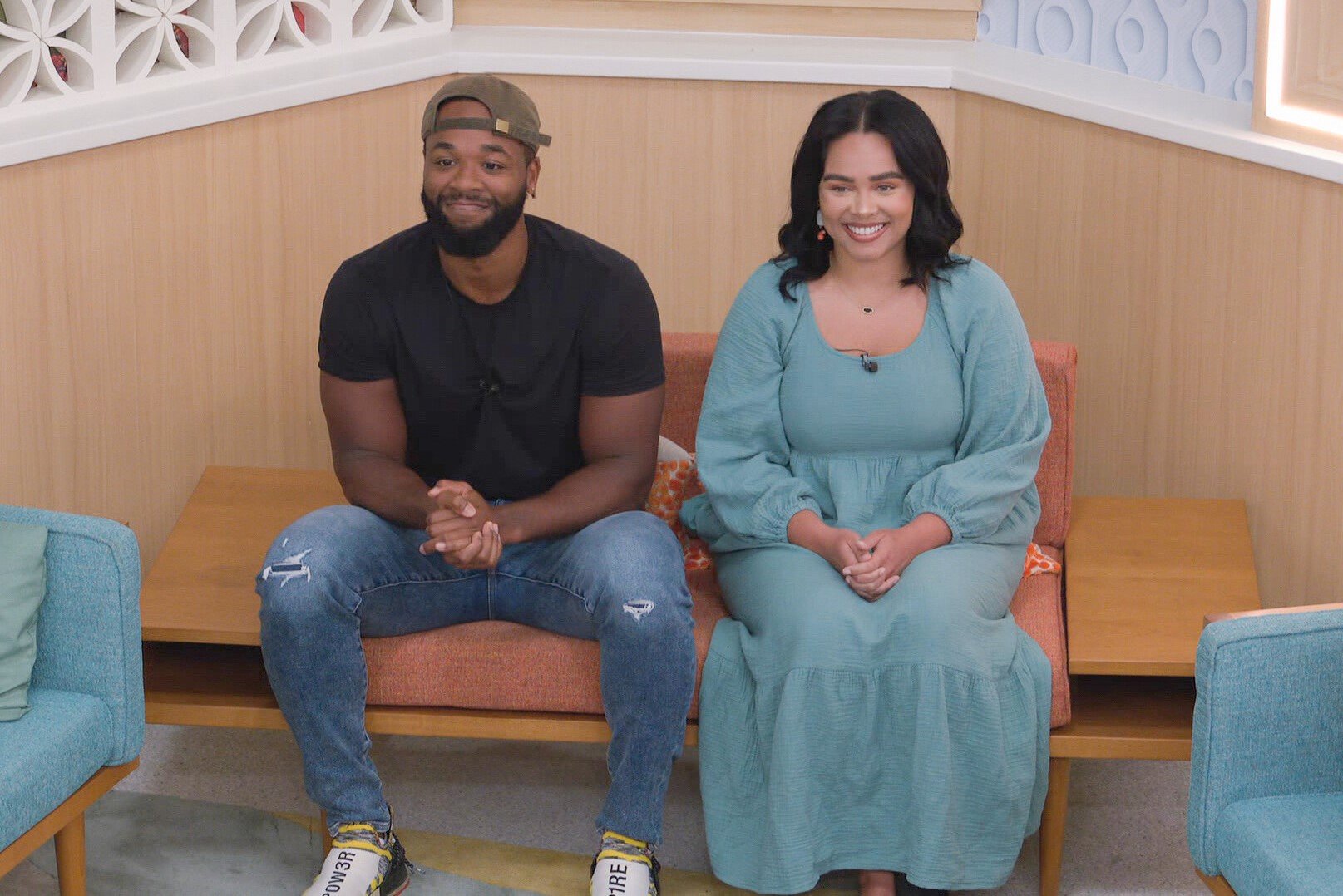 Monte Taylor and Jasmine Davis, who, according to 'Big Brother 24' spoilers, will sit on the block together on live eviction night, sit in the nomination chairs. Monte wears a black shirt, jeans, and a backwards brown baseball cap. Jasmine wears a light blue long-sleeved dress.