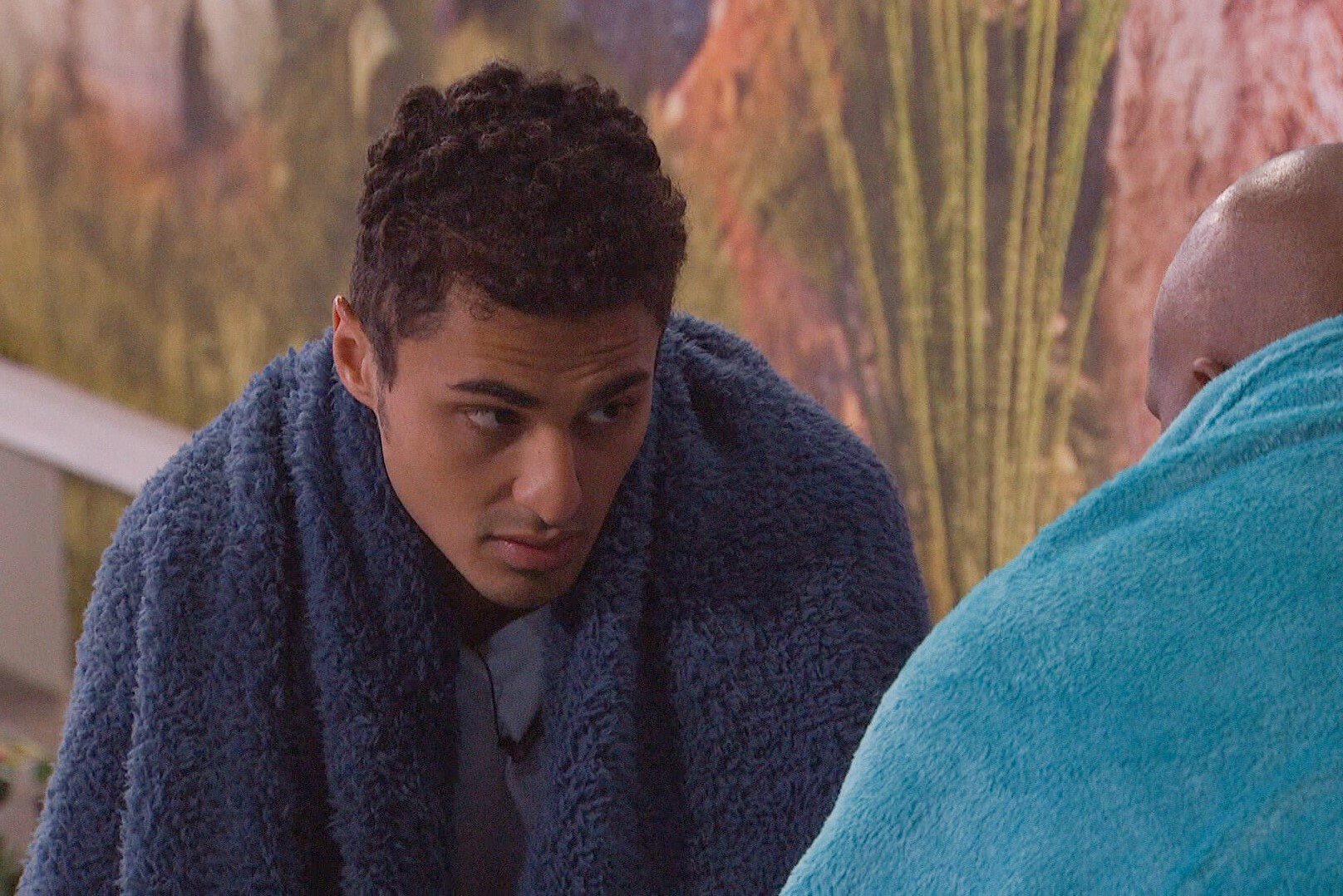 Joseph Abdin, who according to 'Big Brother 24' spoilers is still on the block after the veto ceremony, wears a dark blue blanket over his shoulders and a light blue shirt.