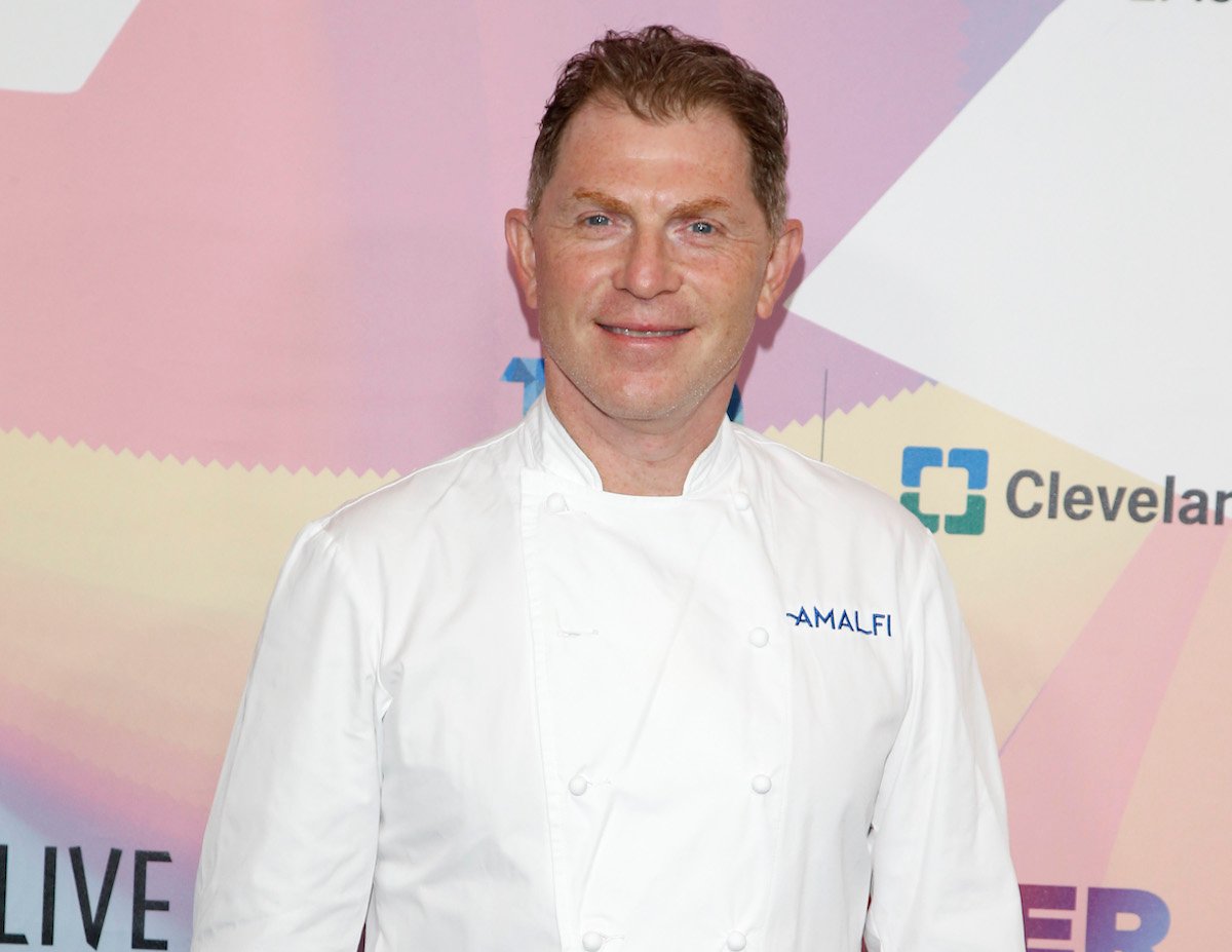 Bobby Flay, who has a simple trick for preventing fish from sticking to the grill, smiles wearing a white chef's coat