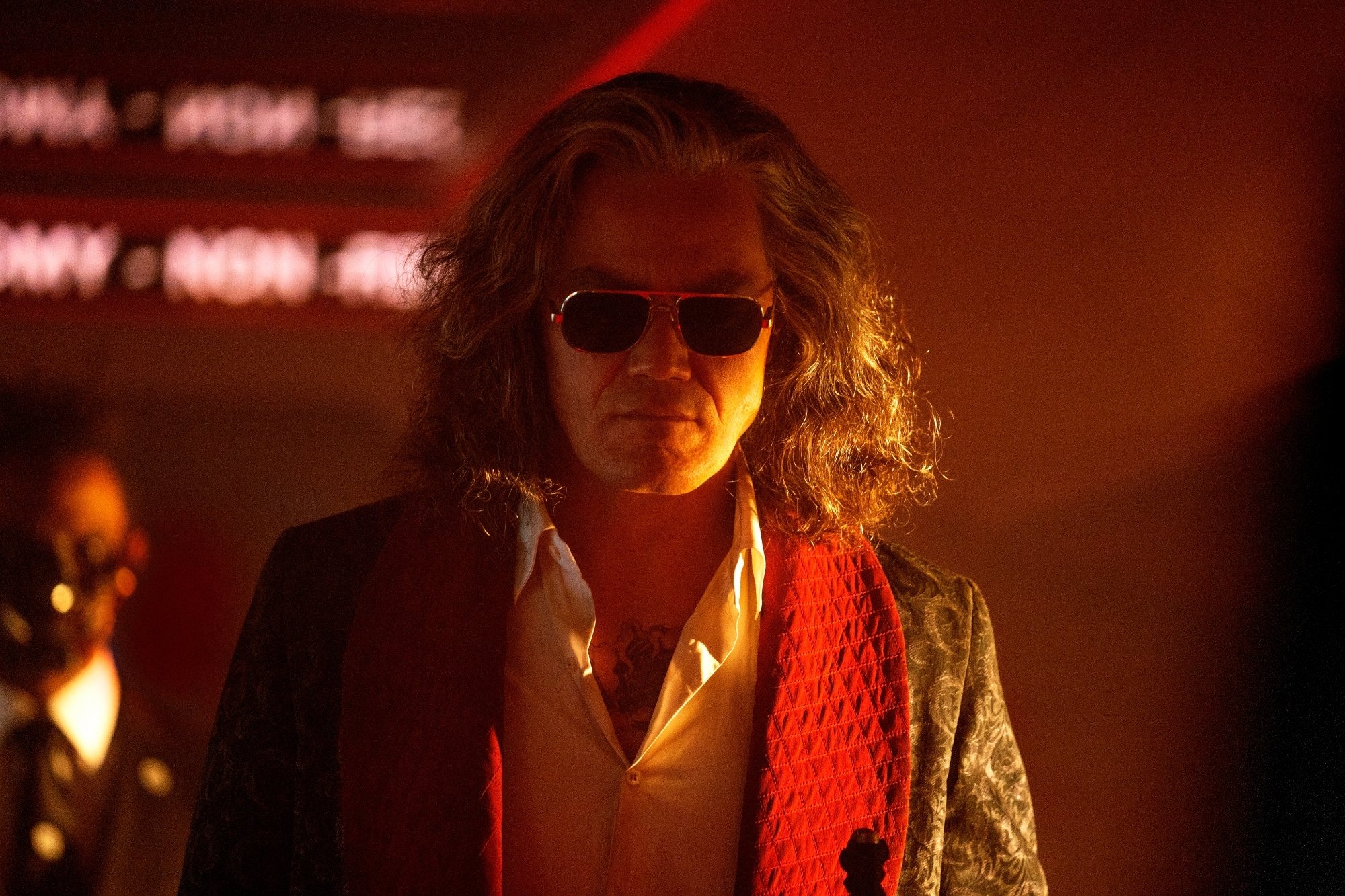 'Bullet Train' Michael Shannon as White Death, which involves Channing Tatum cameo. Shannon is wearing a robe with a white collared shirt underneath it and sunglasses.