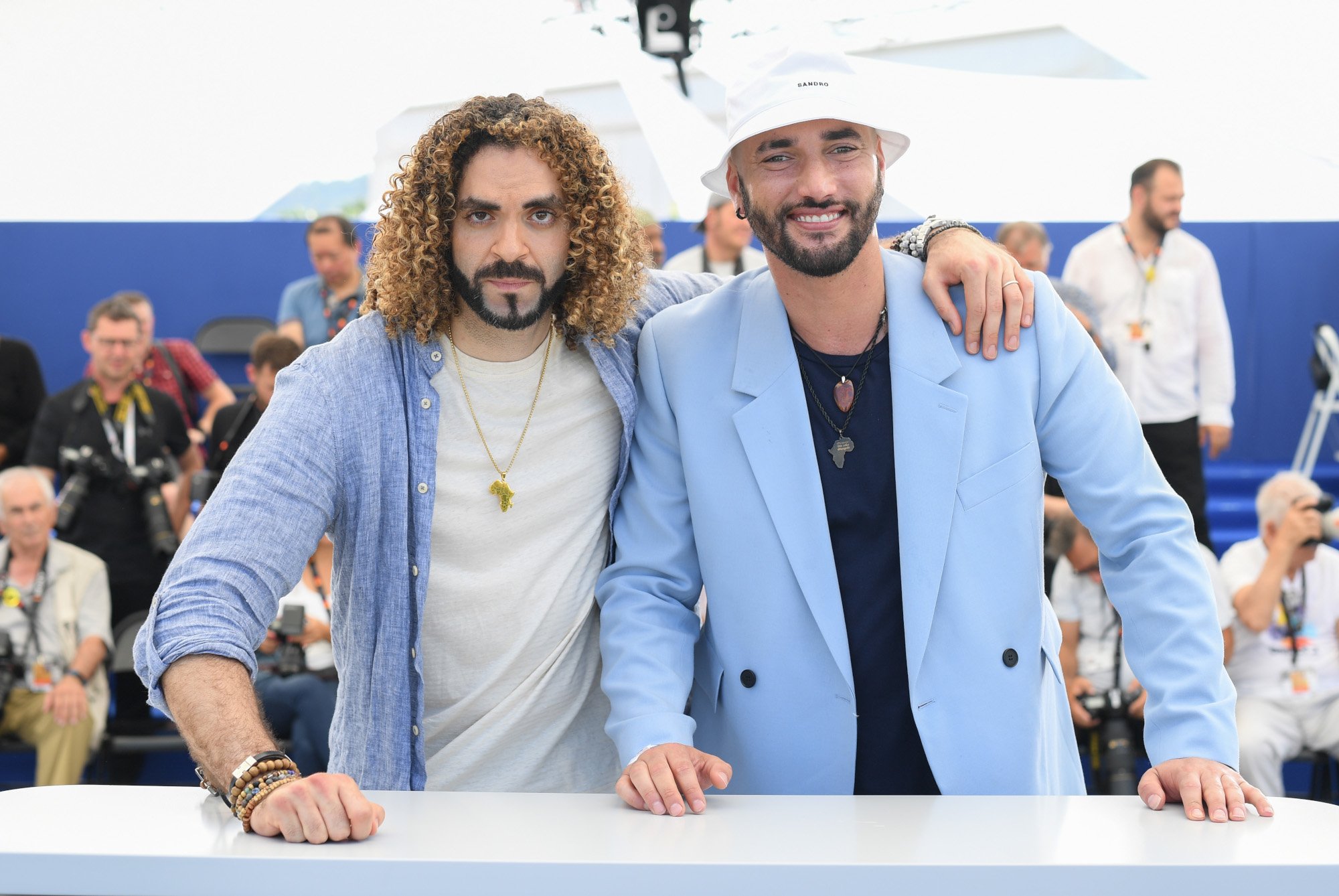 'Batgirl' directors Adil El Arbi and Bilall Fallah, who responded to the movie being canceled. Adil El Arbi has his arm around Bilall Fallah, and he's wearing a white shirt and blue button-up. Fallah is wearing a black shirt and blue blazer.