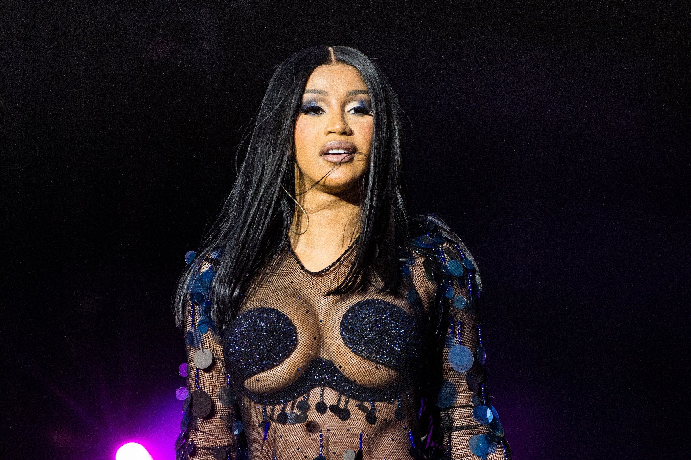 Cardi B, who uses onions for her hair, wearing a black outfit on stage