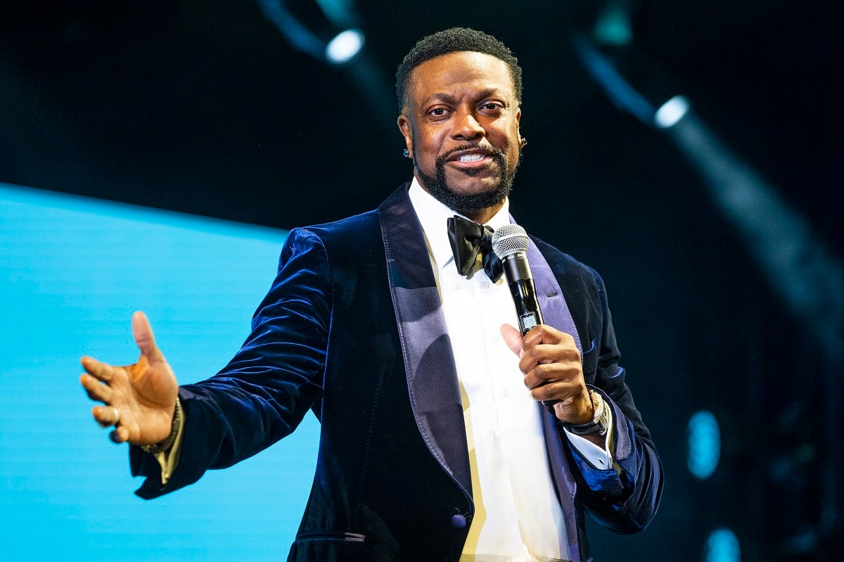 Chris Tucker performing while wearing a suit.