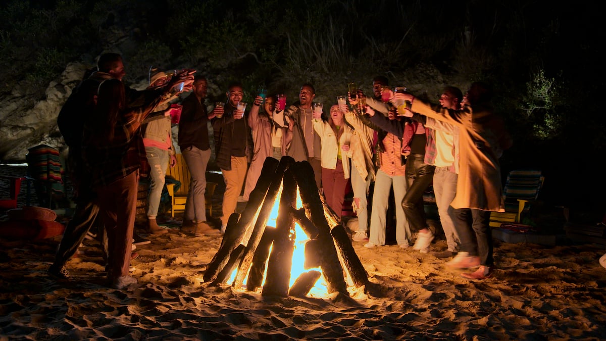 The 'Cosmic Love' cast standing around a bonfire