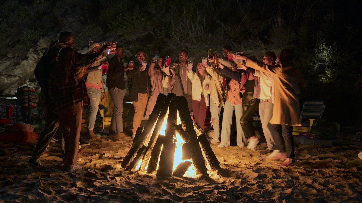 The 'Cosmic Love' cast standing around a bonfire