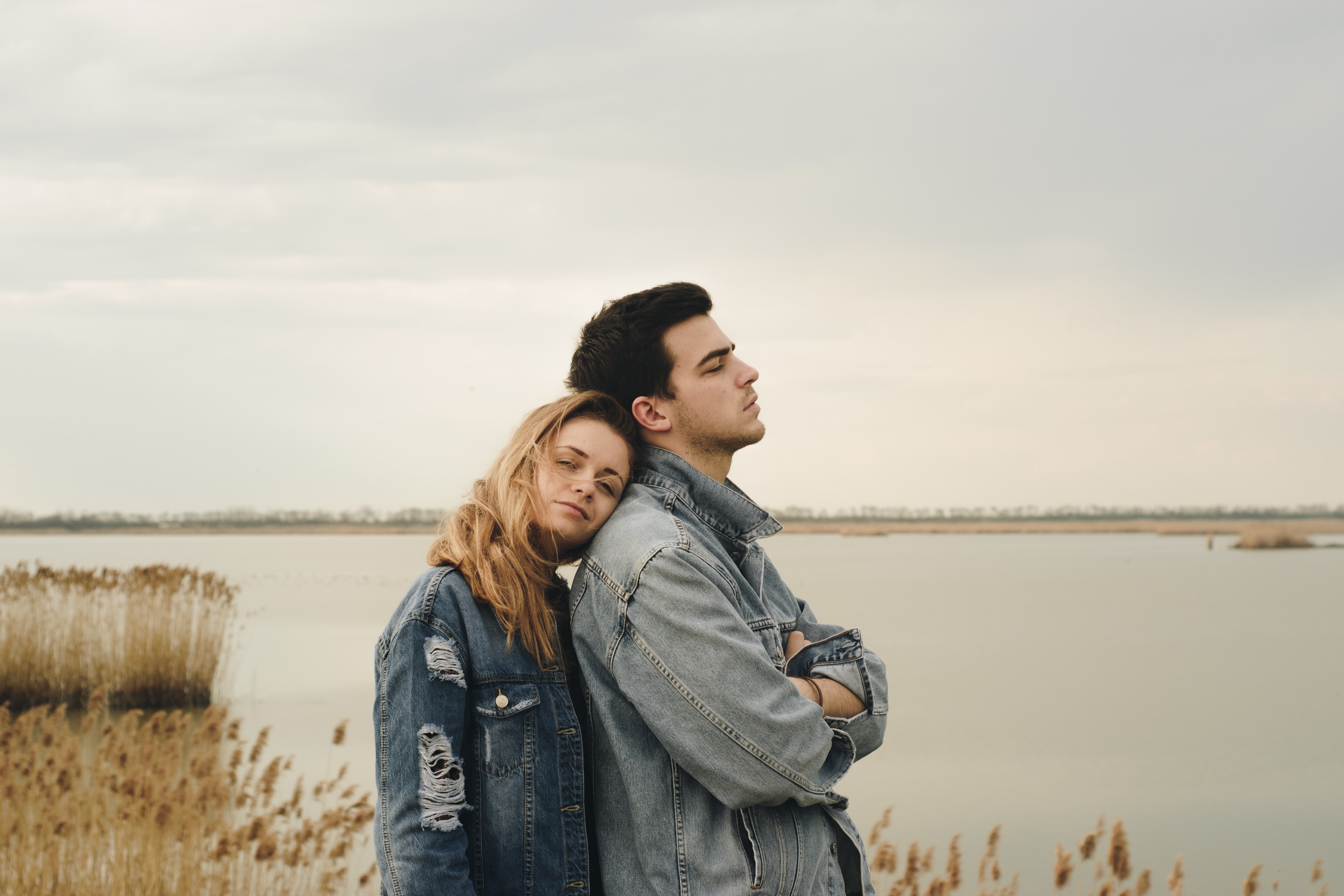 A couple stands near the water