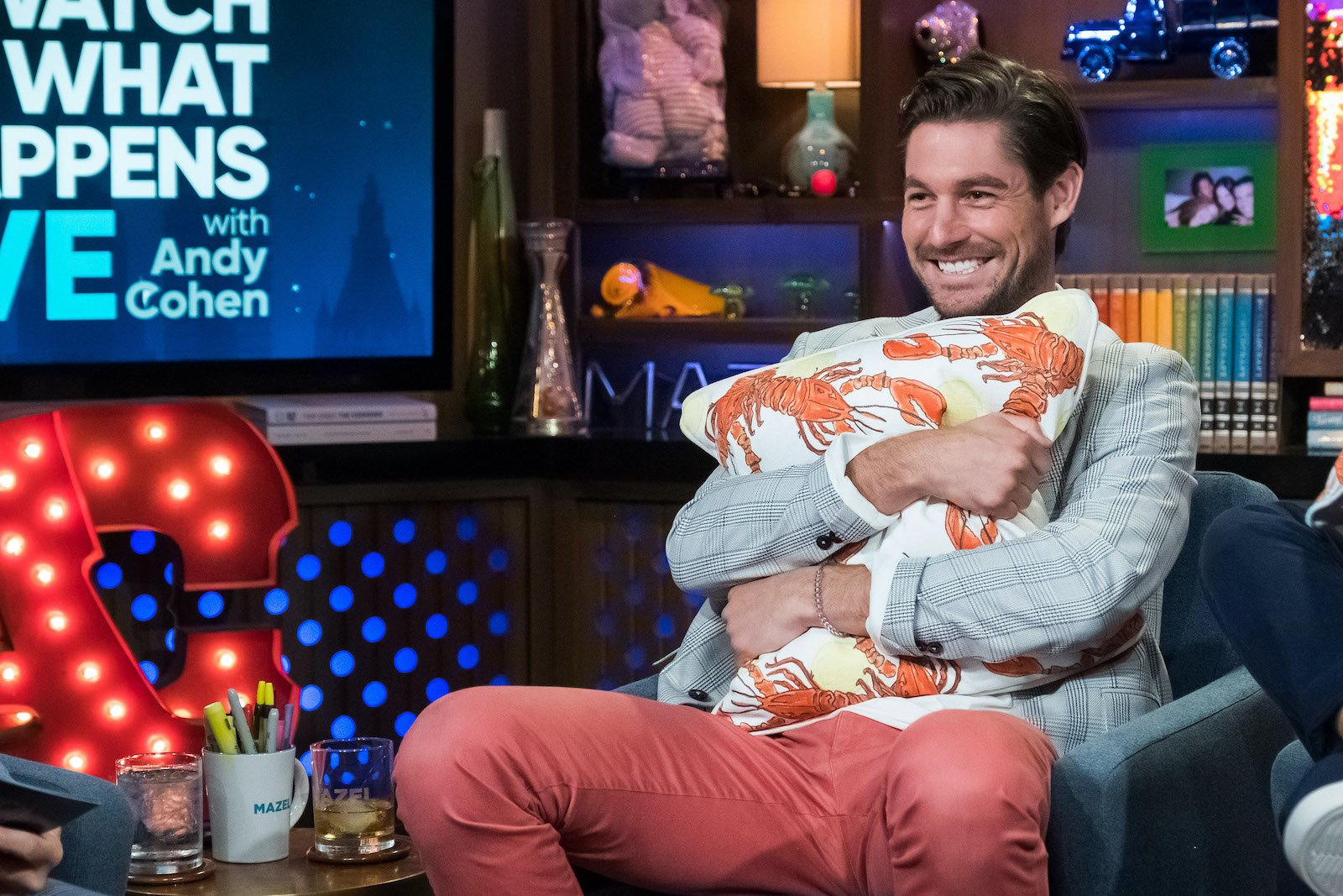 Craig Conover from 'Southern Charm' holds one of his pillows with a lobster pattern on 'WWHL'