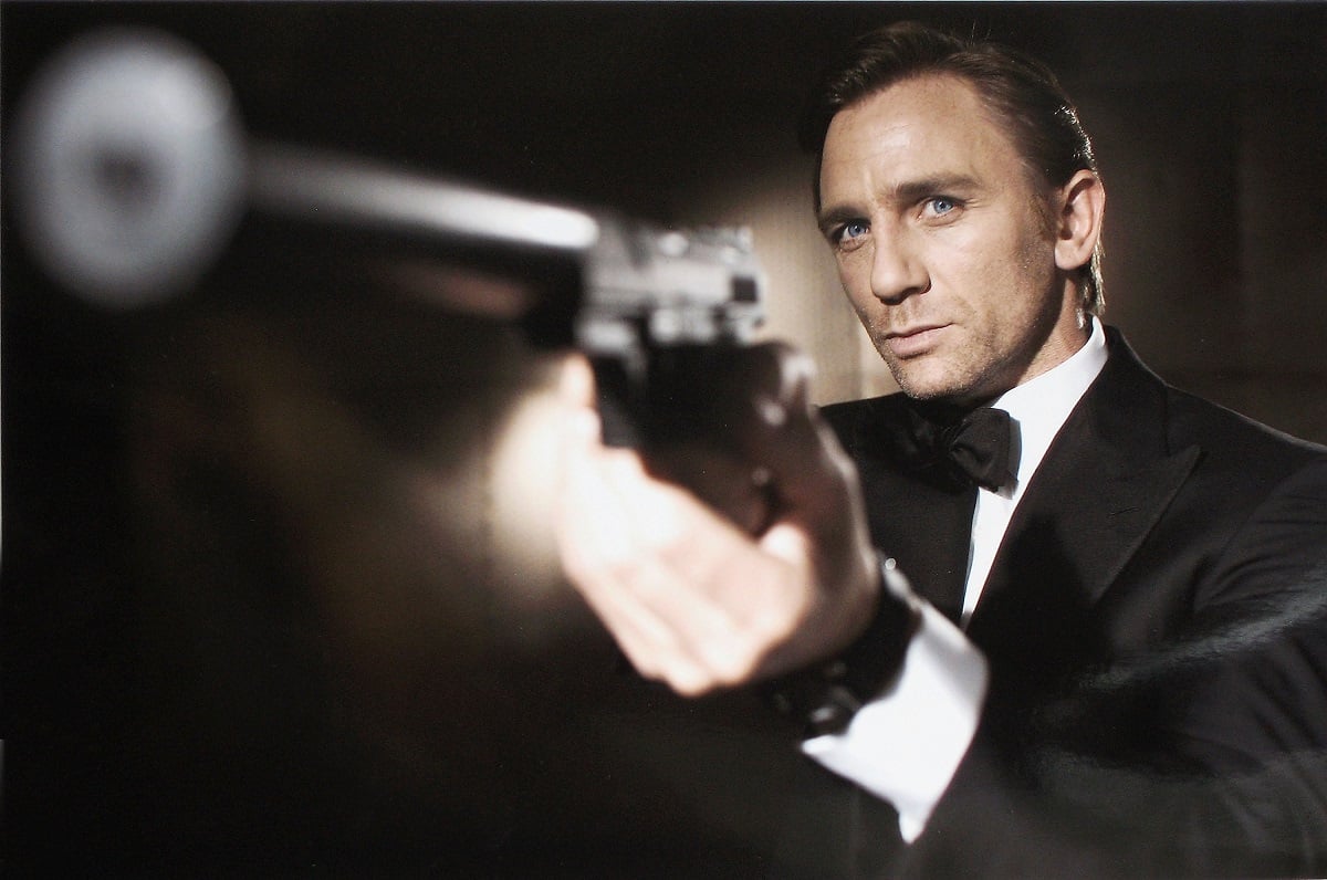 Daniel Craig pointing a gun as James Bond.