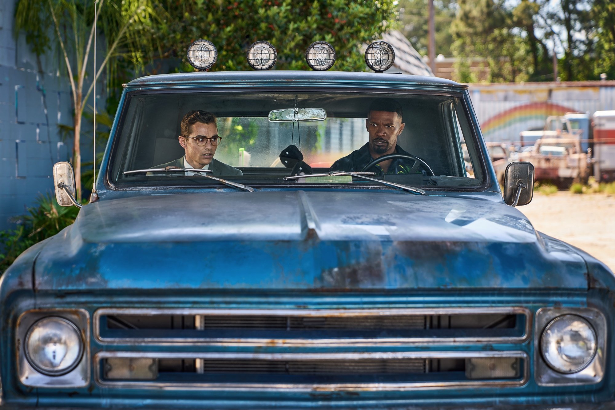 'Day Shift' Dave Franco as Seth and Jamie Foxx as Bud Jablonski sitting in a blue truck looking shocked