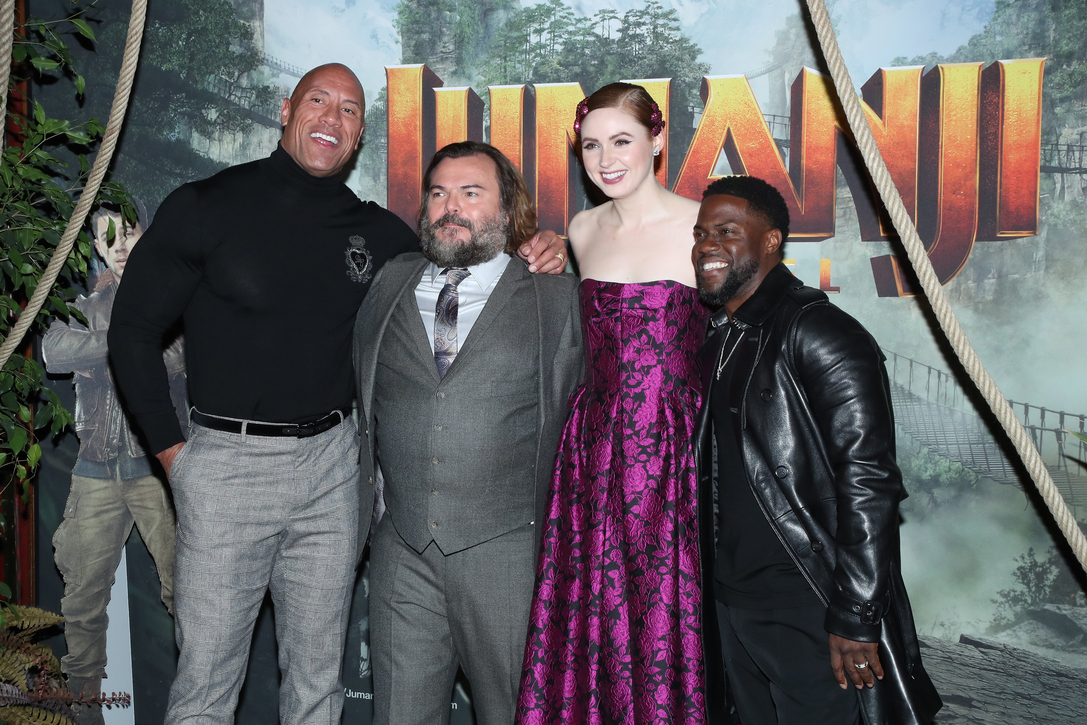 Dwayne 'The Rock' Johnson, Jack Black, Karen Gillan, and Kevin Hart pose on the red carpet at the Jumanji premiere.