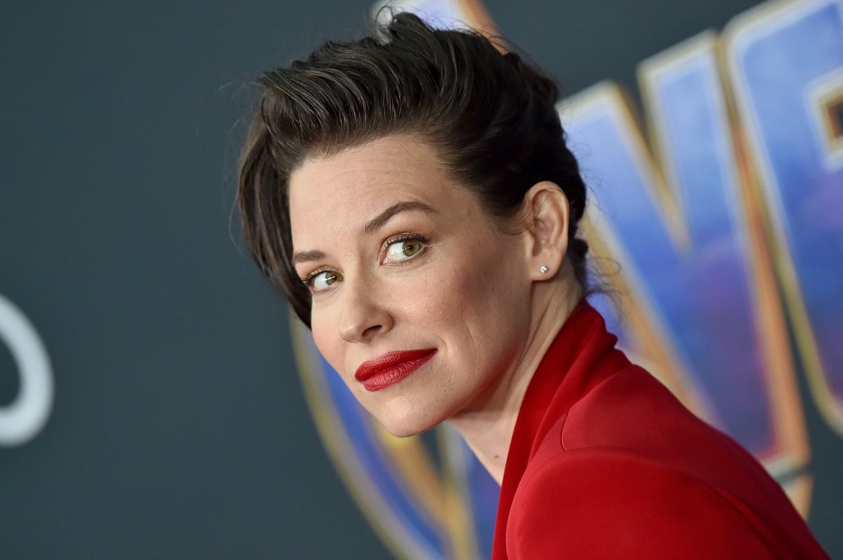 Evangeline Lilly posing while wearing a red jacket.