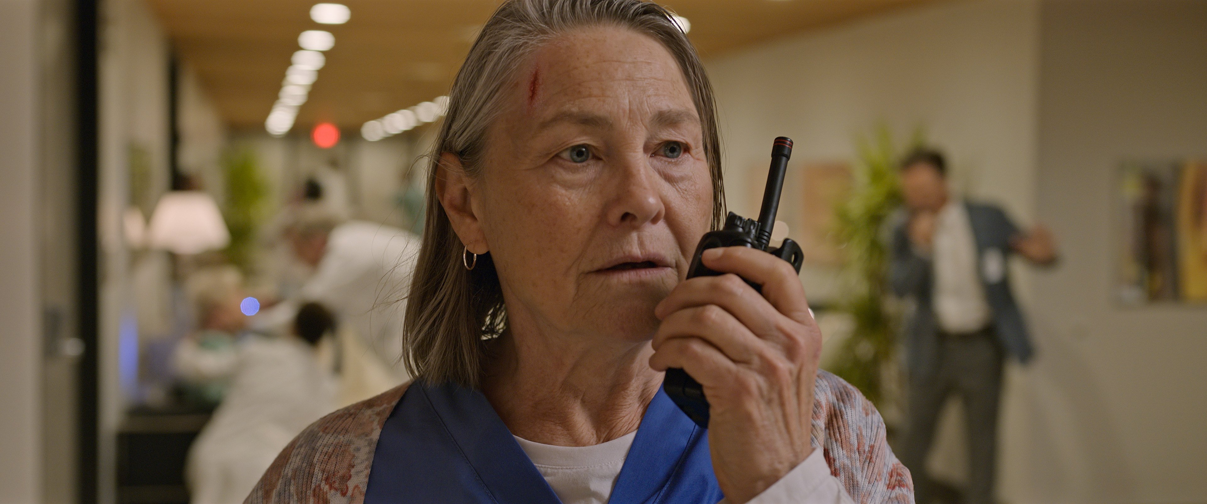 'Five Days At Memorial' cast member Cherry Jones talking into a walkie talkie with a bleeding cut on her head