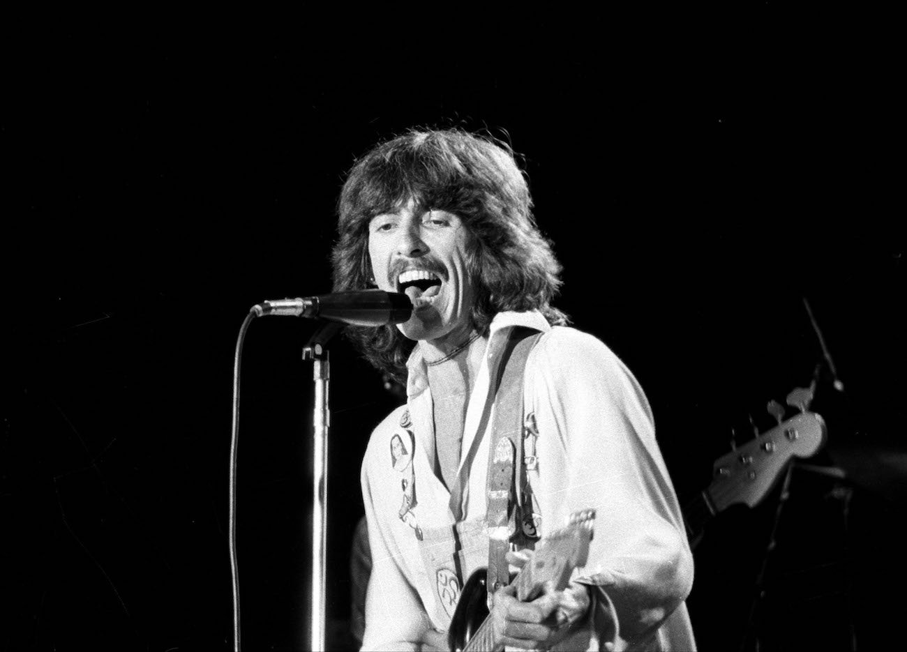 George Harrison performing in white in the 1970s.