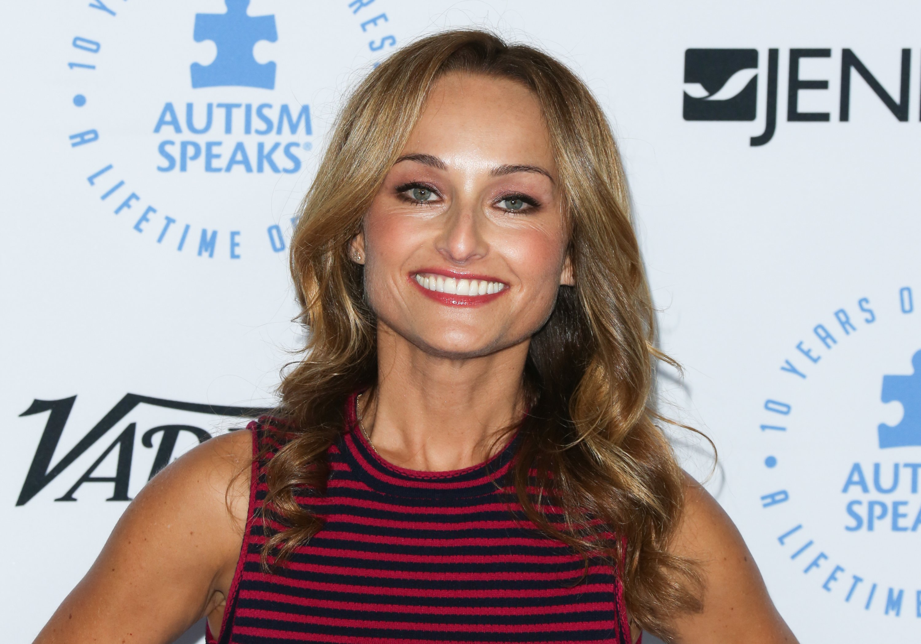 Food Network star Giada De Laurentiis wears a black and red striped sleeveless top in this photograph.