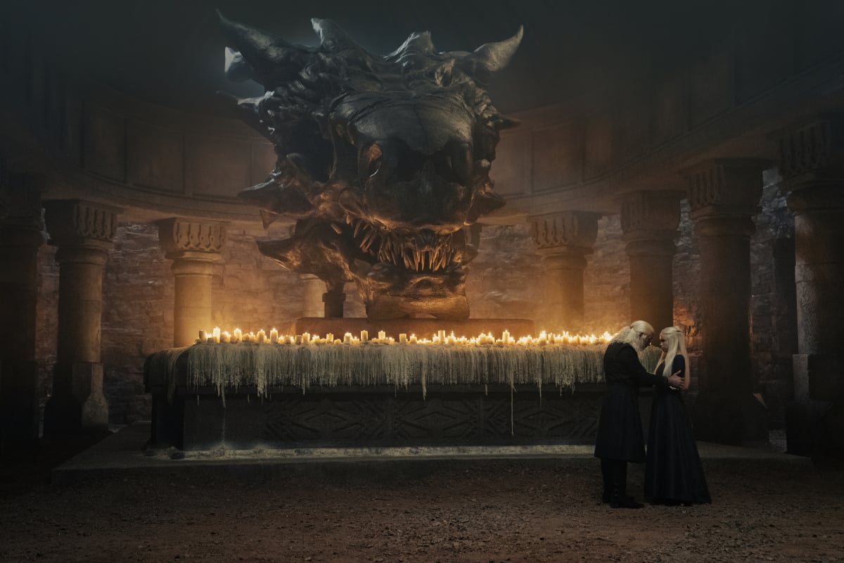 Paddy Considine as King Viserys and Milly Alcock as Rhaenyra in House of the Dragon stand in front of the Sept lit with candles.