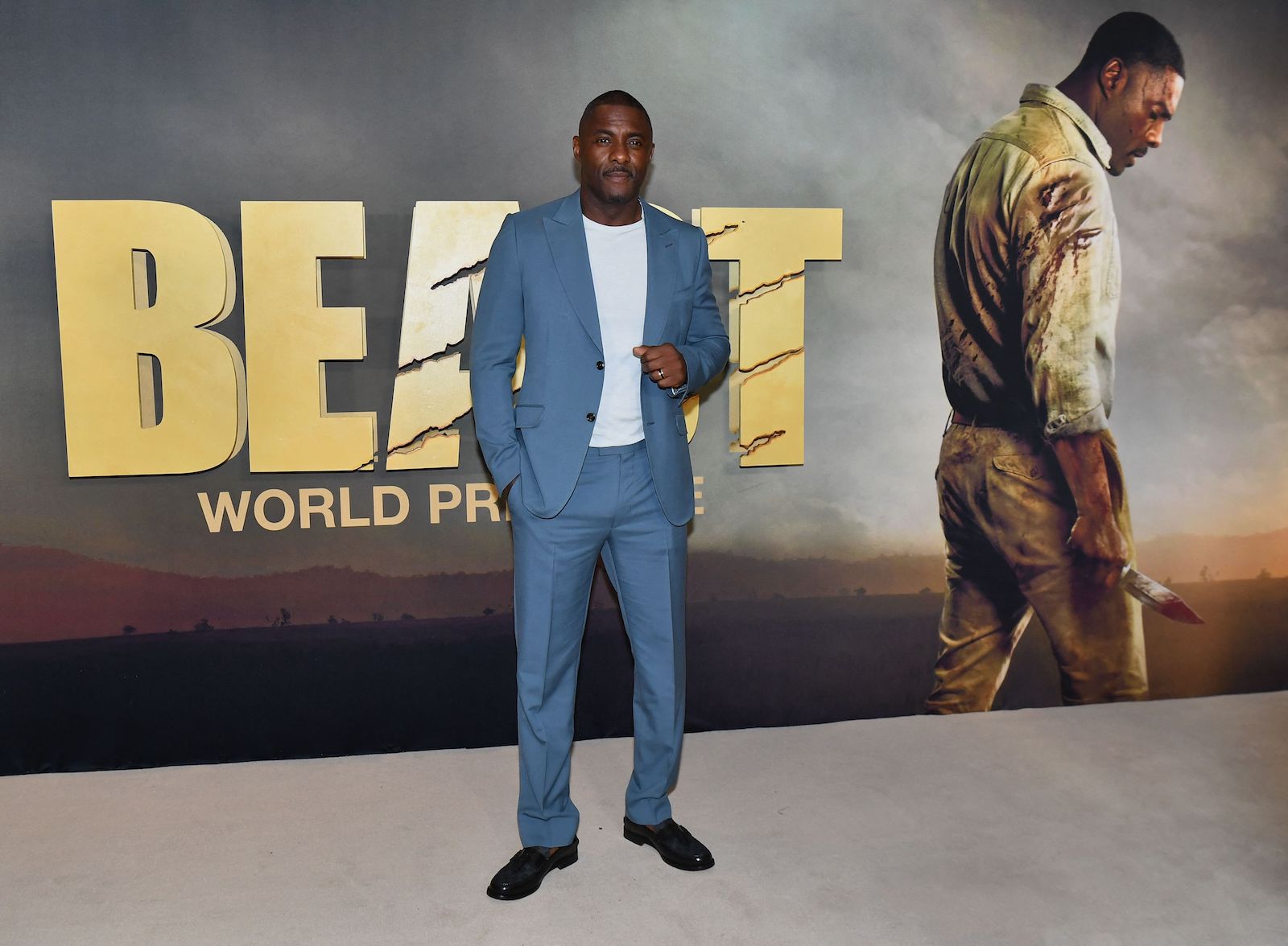 Idris Elba poses in front of the 'Beast' poster
