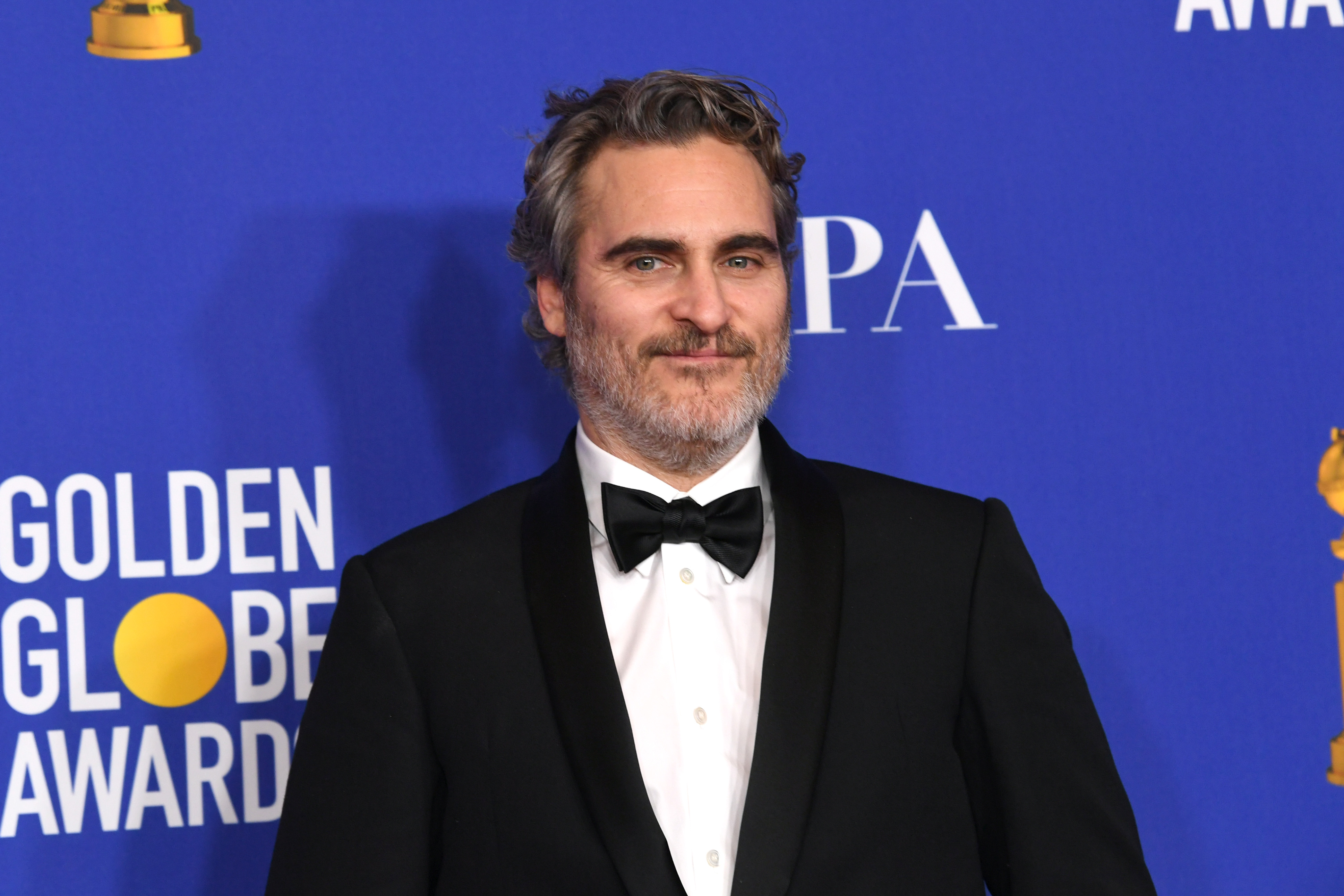 Joaquin Phoenix wears a tuxedo at a media event.