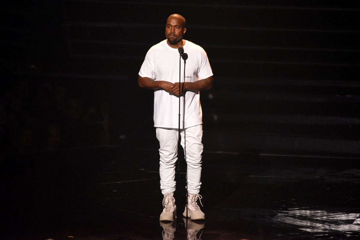 Kanye West speaking in front of a microphone.