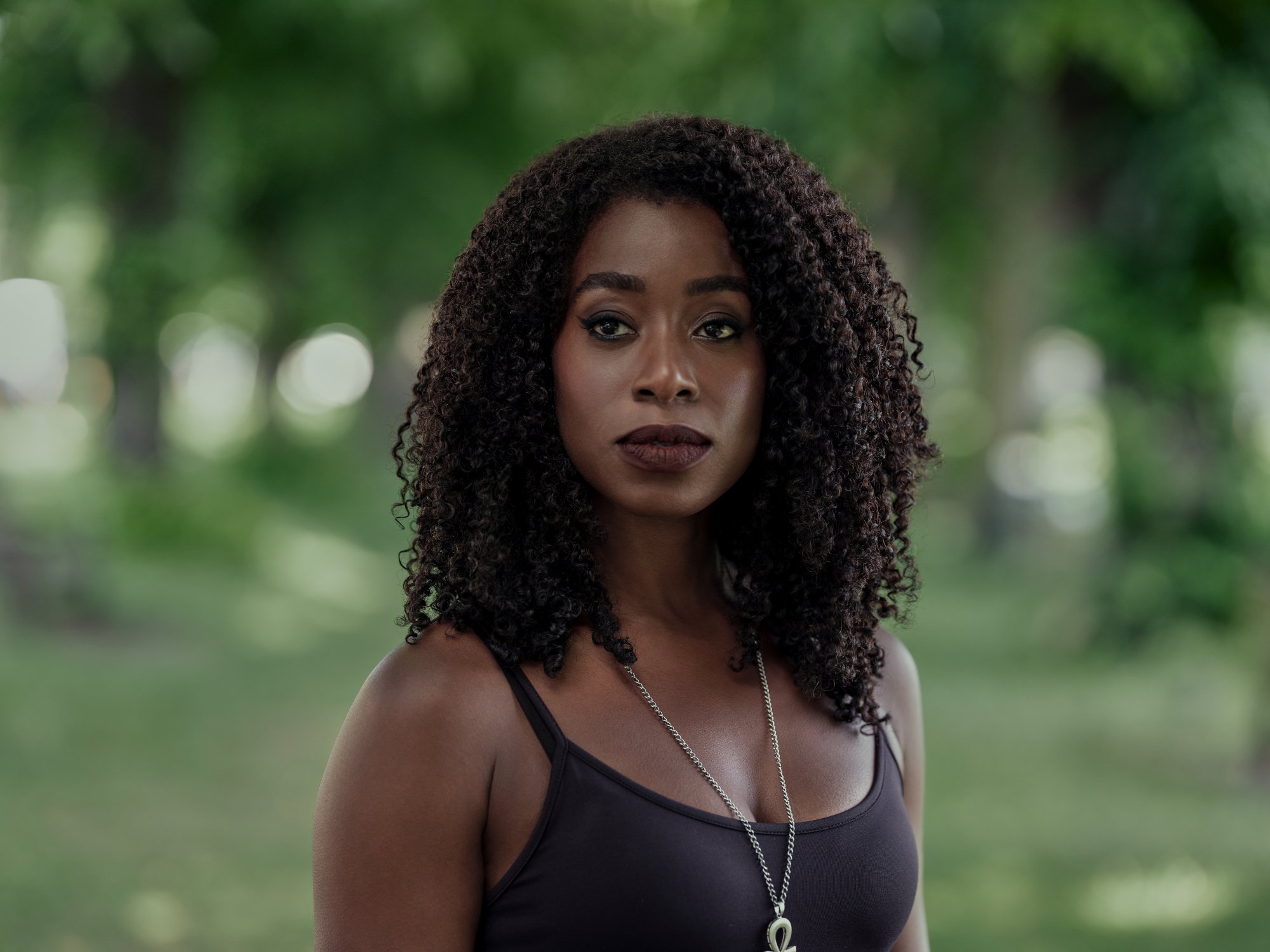 Kirby Howell-Baptiste in the cast of Netflix's 'The Sandman.' In the image, her hair is down and curled and she's wearing a black tank top.