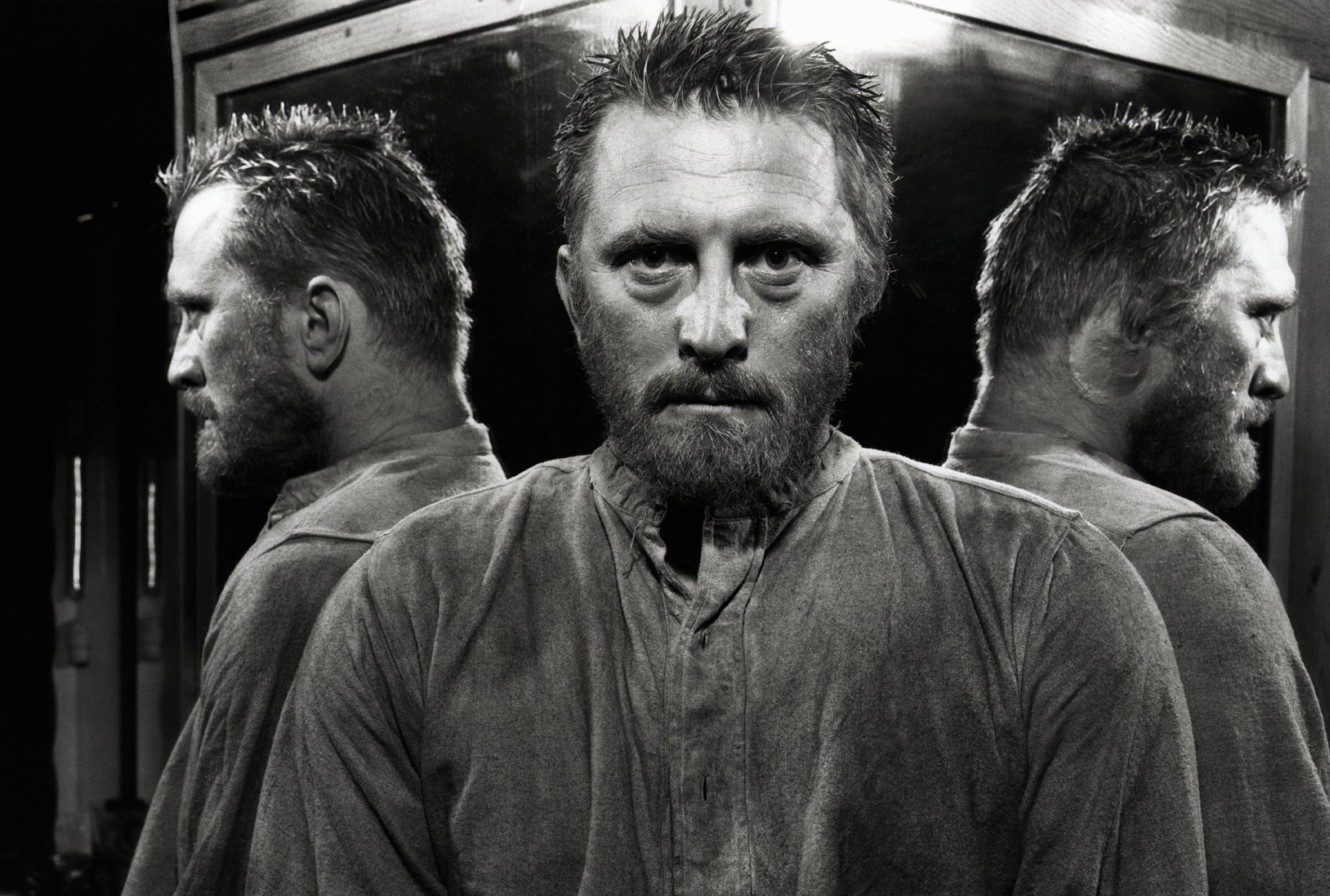 'Lust for Life' Kirk Douglas as Vincent van Gogh, which John Wayne 'berated' him for. Black-and-white image of Douglas looking into the camera with mirrored images of himself on either side.