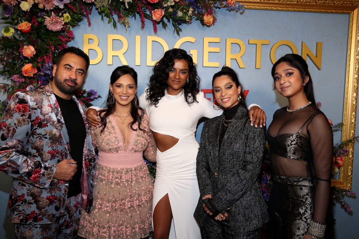 (L-R) Kal Penn, Versha Sharma, Lilly Singh, Simone Ashley, and Maitreyi Ramakrishnan posing together in front of a Bridgerton sign