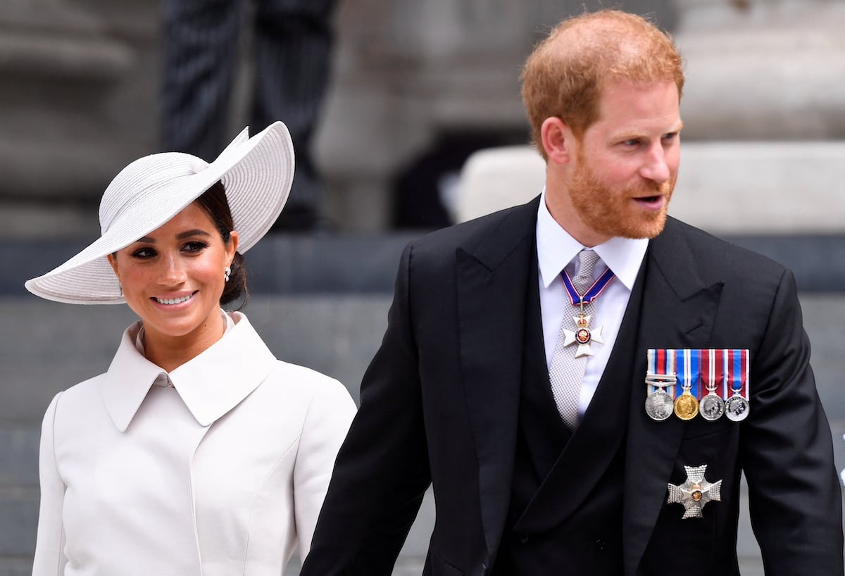 Meghan Markle and Prince Harry, who may have a problem when Prince William and Kate Middleton visit according to a commentator, look on